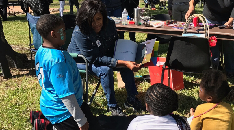 Adrienne Bell reading a story book to children