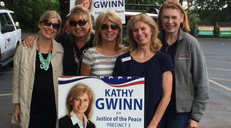 Kathy Gwinn with her supporters holding the campaign poster