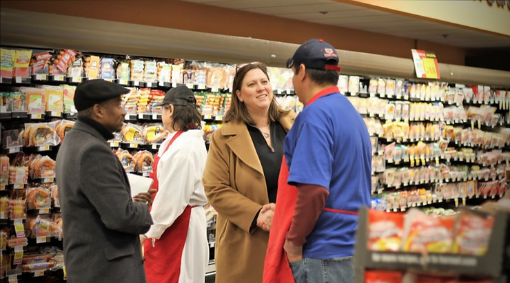 julie johnson talking with person in grocery store